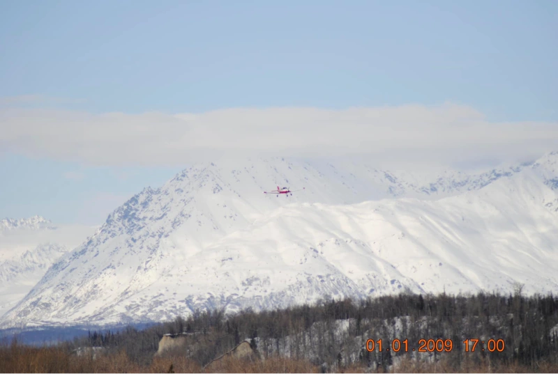 small plane flying over snowy mountains winter flying